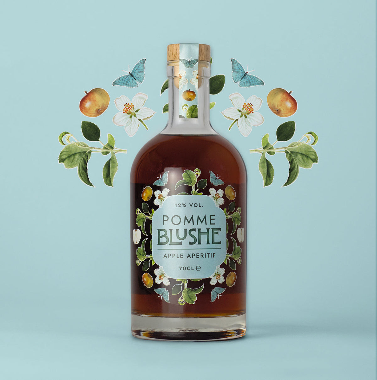 A bottle of Pomme Blushe apple aperitif with an illustration of apples and leaves in the background.
