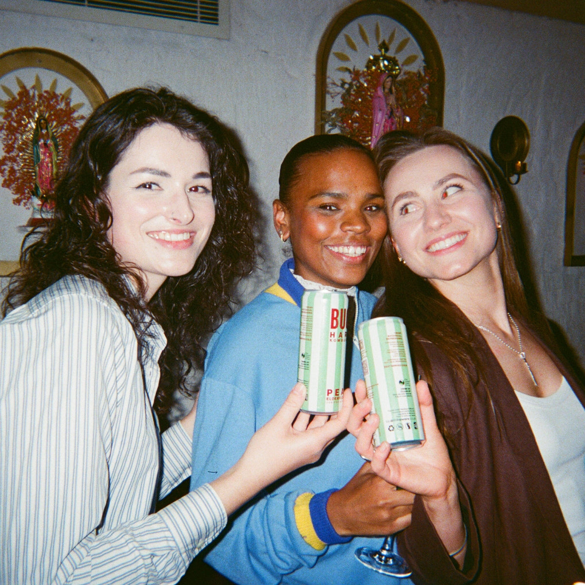 BUCI hard kombucha drink being held at a bar with people smiling