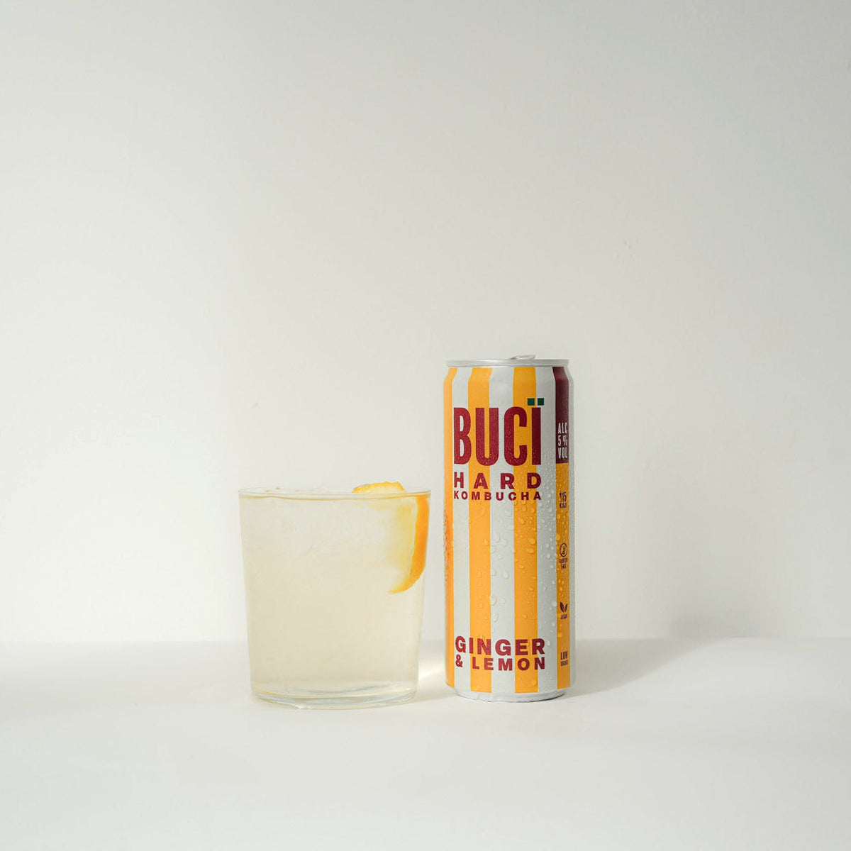 A can of BUCÏ Lemon and Ginger Hard Kombucha next to a glass.