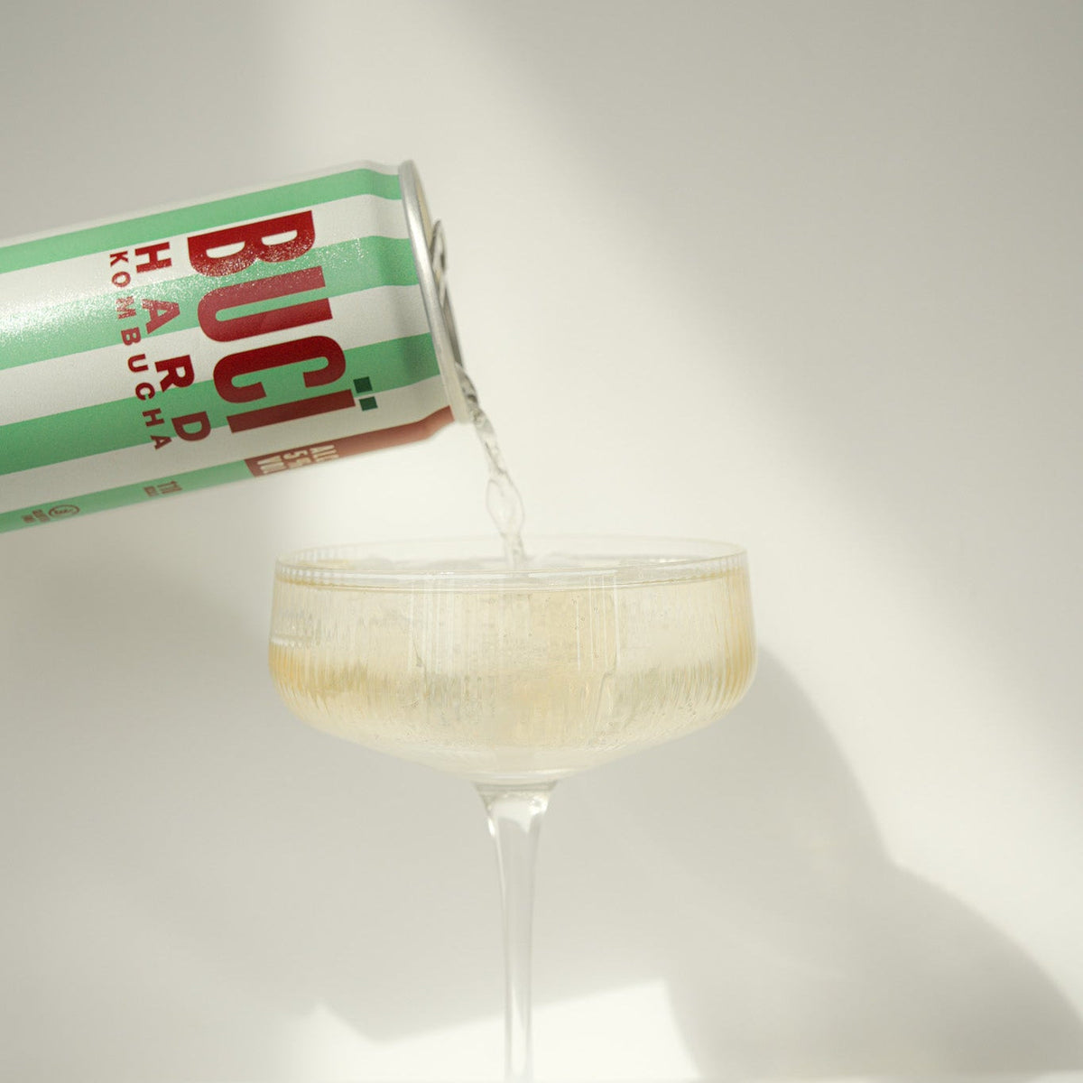 BUCÏ Pear & Elderflower Hard Kombucha – 330ml can being poured into a glass.