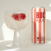 A can of BUCÏ Wild Berries Hard Kombucha next to a glass.