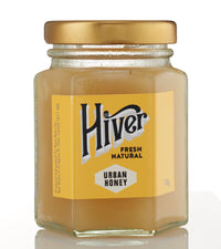 Closed jar of Hiver London Urban Honey with gold lid on a white background