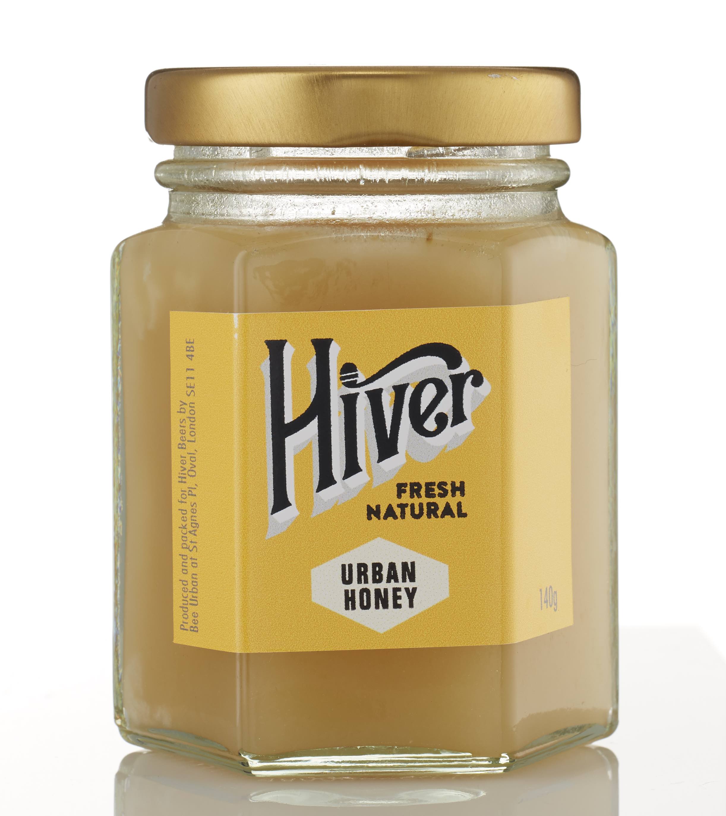 Closed jar of Hiver London Urban Honey with gold lid on a white background