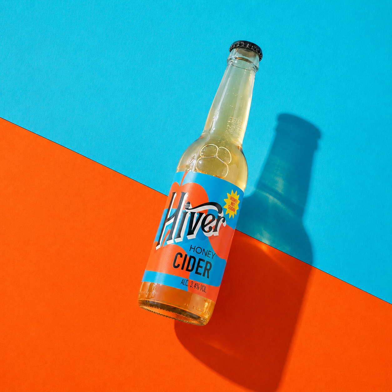 Bottle of Hiver Honey Cider standing on a bold blue and orange background