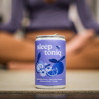A lady doing yoga whilst drinking a sleep toniq