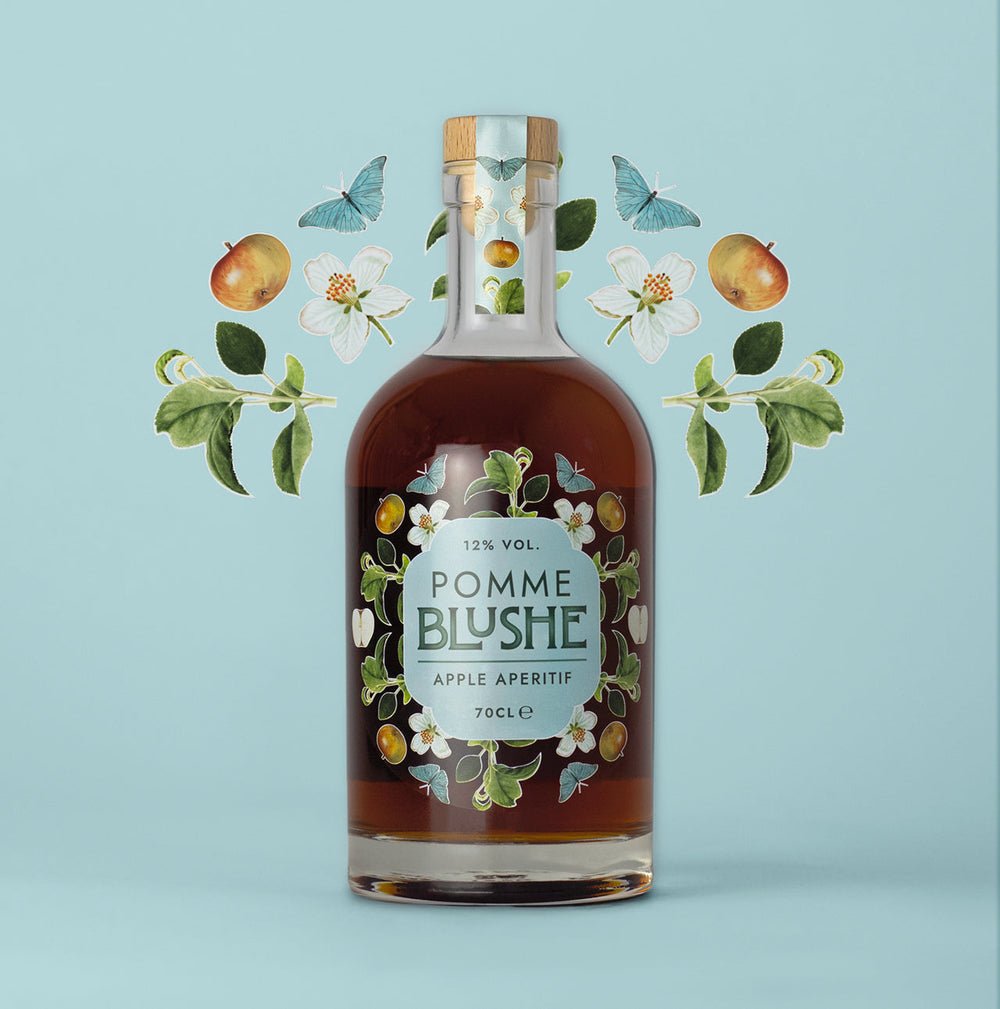 A bottle of Pomme Blushe apple aperitif with an illustration of apples and leaves in the background.