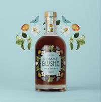 A bottle of Pomme Blushe apple aperitif with an illustration of apples and leaves in the background.